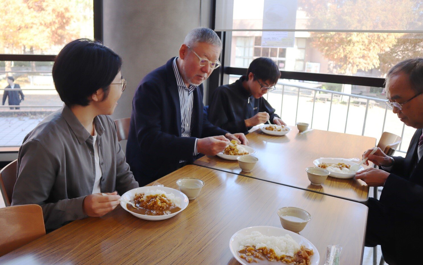 大学生協の100円カレーをコマツの副本部長と農学部の学生が一緒に味わっている理由 <br>―農業用ブルドーザーを使った実証研究の収穫米を寄贈